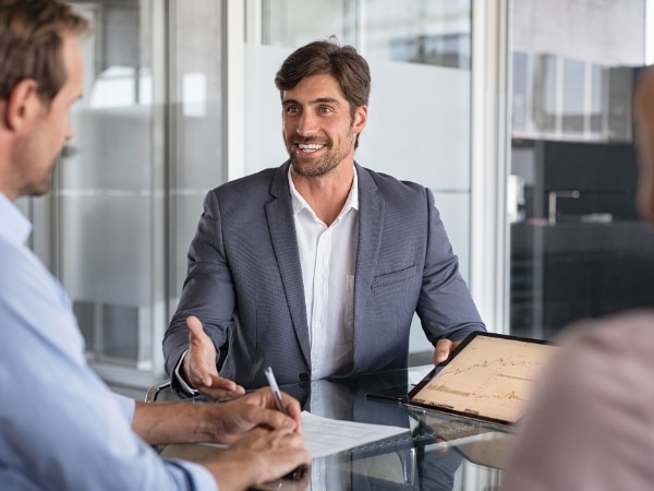 Un consulente per mutuo sorride e spiega le opzioni di finanziamento a un cliente.